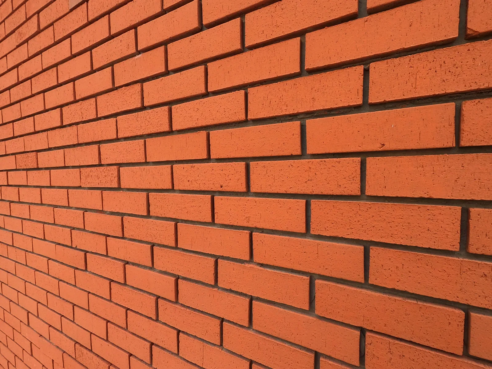 Detailed texture of a red brick wall for background and design use.