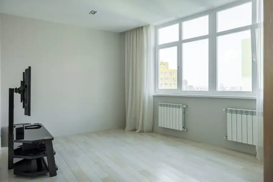 Spacious and bright minimalist apartment with large windows and hardwood floors.